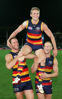 Brent Reilly of the Crows is chaired off after his 200th game by Ben Rutten & Scott Thompson.