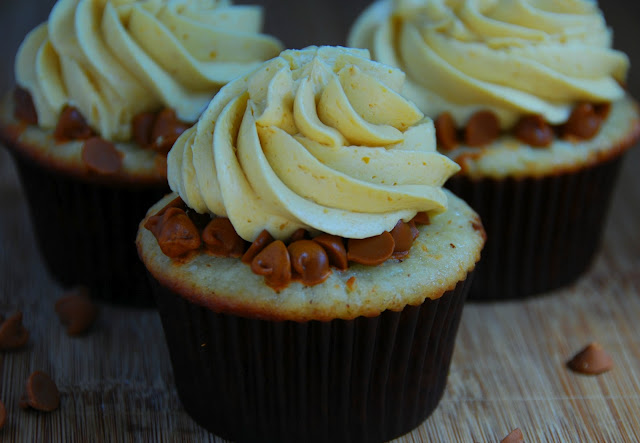 close up of cupcake in brown wrapper with swirl of white icing on top