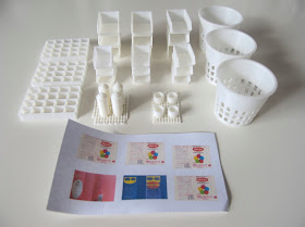 Selection of 3d-printed modern dolls' house miniatures, including storage containers, waste baskets and spray cans.