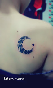 a totem type of crescent moon tattoo with a little star next to it 