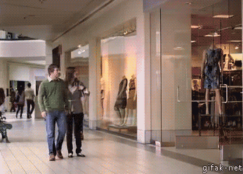 Animated gif of a woman handing a man her purse to hold at a mall, who immediately drops it and picks it up again with an inside-out plastic bag so he doesn't have to touch it and no one can see him holding it.