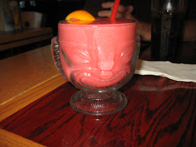 A raspberry daiquiri served in a tiki glass.