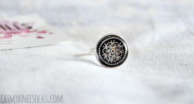 LaurasPills Jewelry Review: Hand-painted Ring The ring from LaurasPills is silver and adjustable, with the print enhanced by a glass cabochon, just like the necklace. The metal portion of the ring is lightweight but not flimsy, and it fits comfortably.