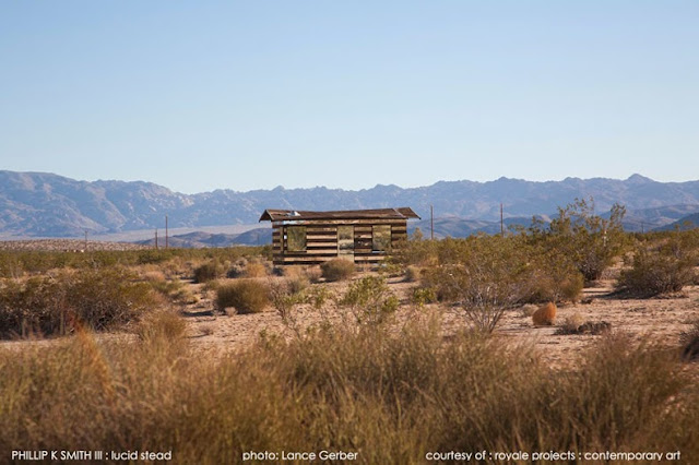 Cabaña transparente de madera y espejos en un paisaje desértico