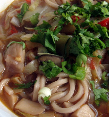 fresh ramen noodles in broth with oyster mushrooms and cabbage