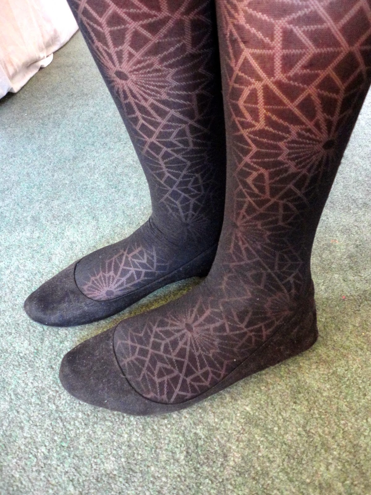 black cobweb patterned tights and flat shoes