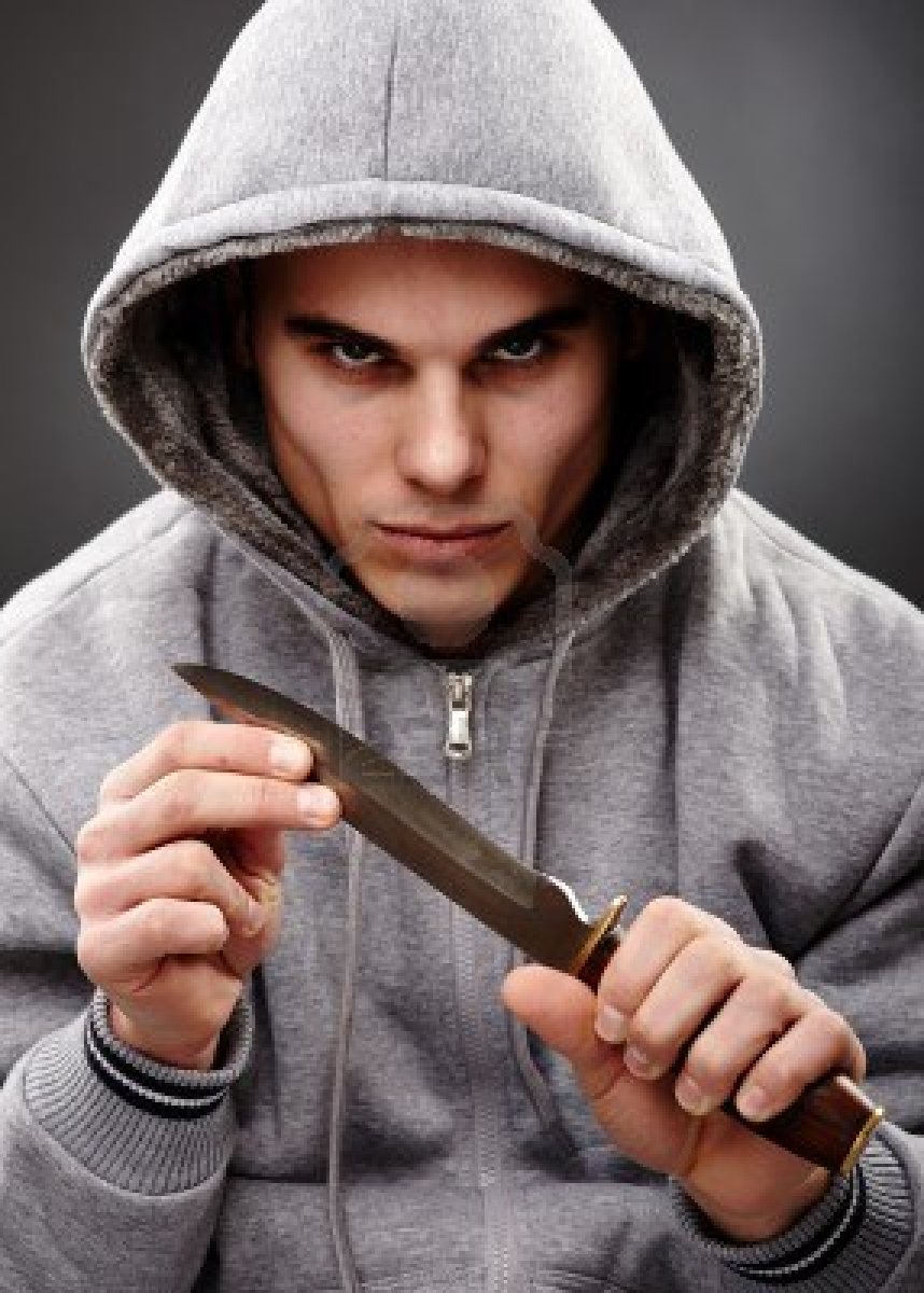 18159160-closeup-portrait-of-a-threatening-mafia-man-holding-a-knife-in-his-hands-over-gray-background-repres.jpg