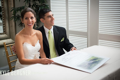 The Bride and Groom smiling and holding the Ketubah after signing