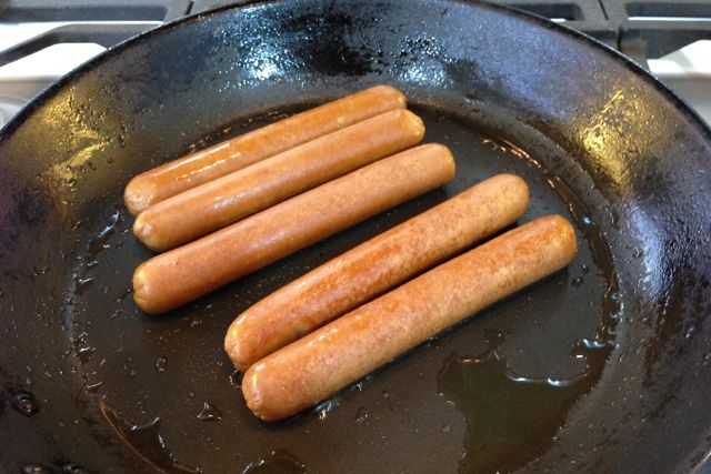 Vegan Hot Dog Sausages sizzling in a pan