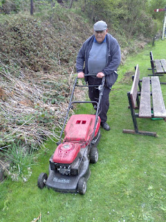 Malcolm cutting grass on Andrews House station platform
