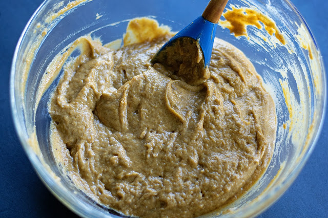 The pumpkin spiced latte batter mixed together, in a bowl, with a rubber spatula in it. 