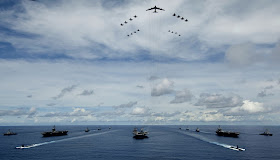 A B-52 Stratofortress leads a formation of Air Force and Navy F-16 Fighting Falcons, F-15 Eagles, and F-18 Hornetst over the USS Kitty Hawk, USS Nimitz and USS John C. Stennis Strike Groups during Exercise Valiant Shield.