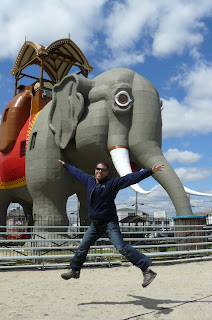 a man standing in front of a statue of an elephant with Lucy the Elephant in the background