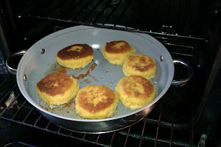 salmon fishcakes browned on one side, flipped and ready to be heated through in the oven