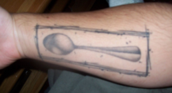 tatuaje de una cuchara en el braso