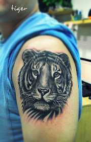 a tiger tattoo on the arm with vivid eyes