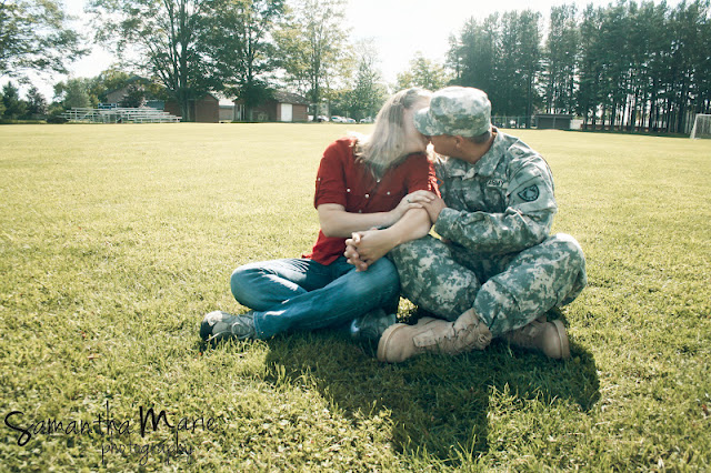 army couple kissing in a field