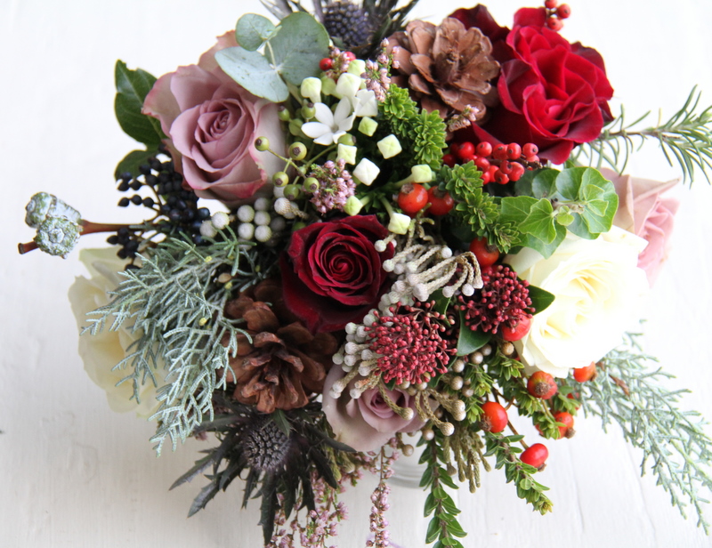 A very rustic style wedding bouquet of Roses Berries Fir Cones and