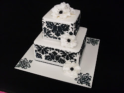 2 tier square stacked stencilled cake with open sugar roses.