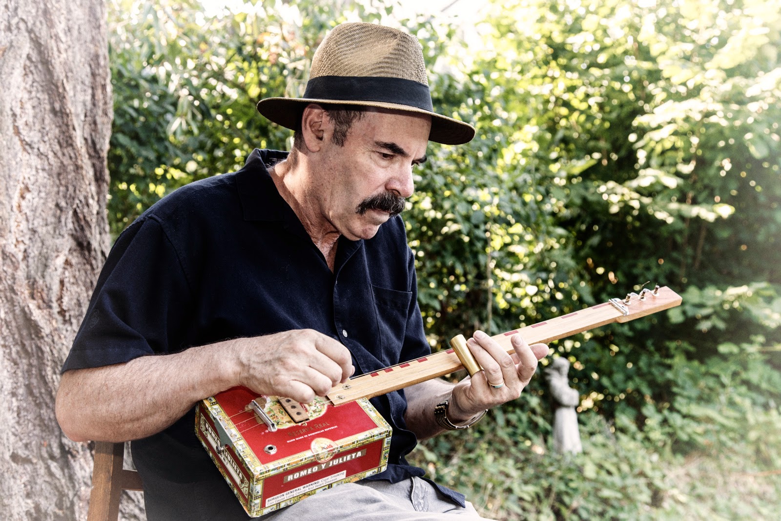 Stephen plays his custom made red cigar box guitar