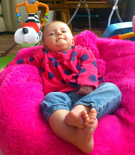 barefoot baby chills on pink beanbag