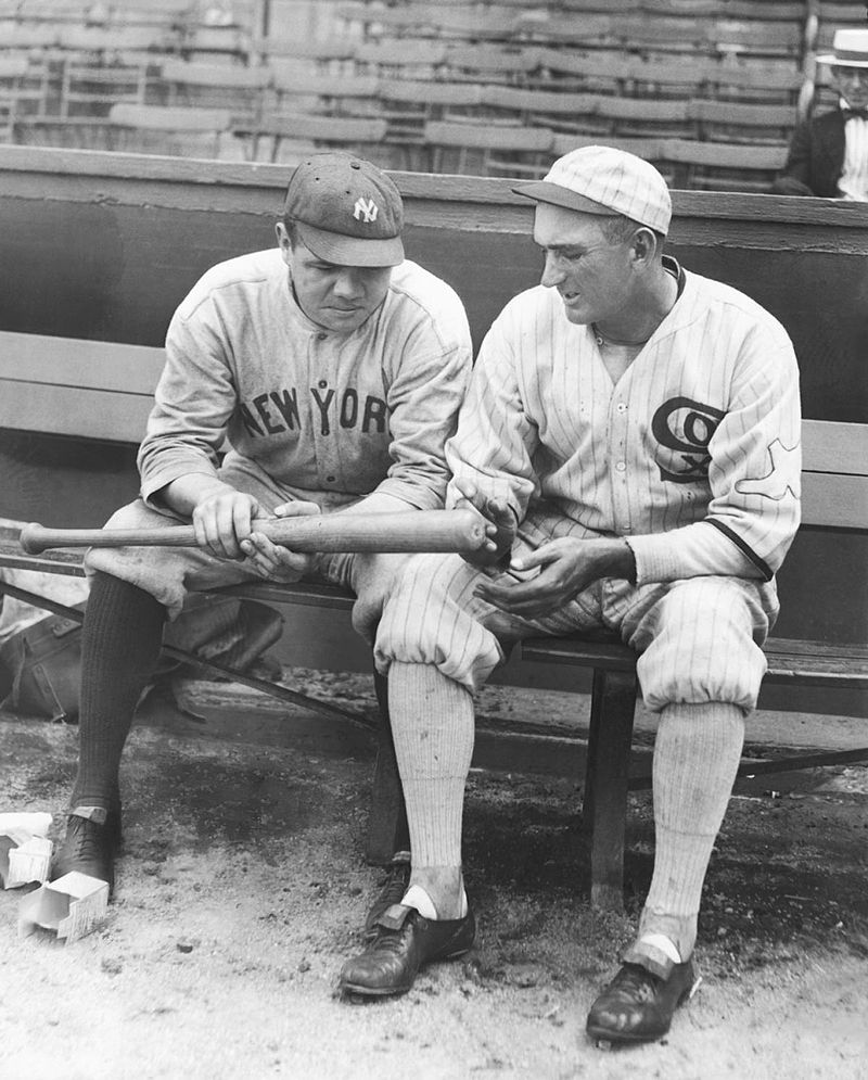 Ruth and Shoeless Joe Jackson looking at one of Babe's home run bats, 1920