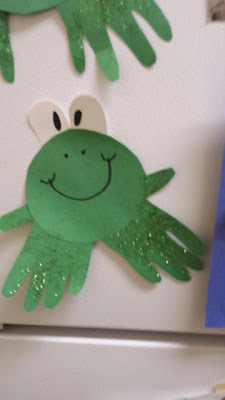 handprint frog craft hanging on the fridge