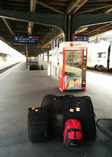 Bike bag, suitcase, and backpack on the train platform in Fribourg, Switzerland