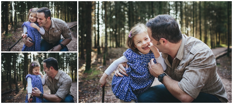 Natural family photos of a father and daughter laughing together in a forest