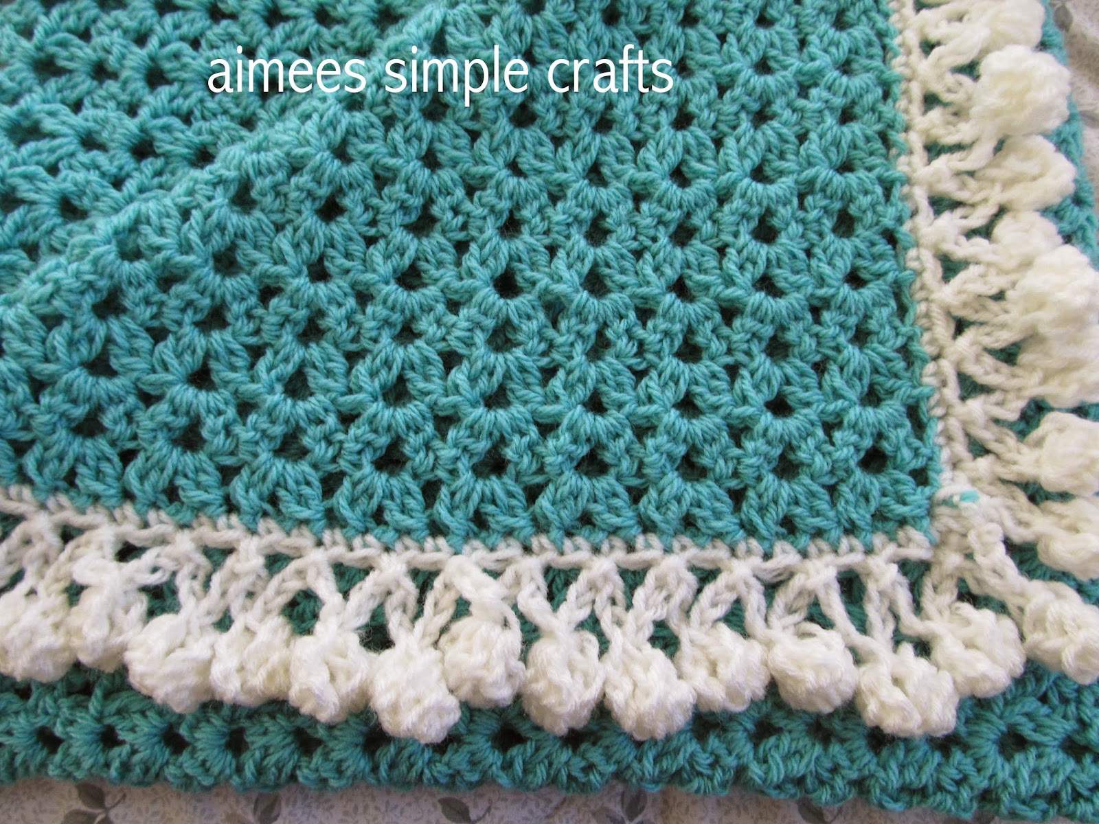 CLUSTER STITCH BABY BLANKET WITH POMPOM EDGING