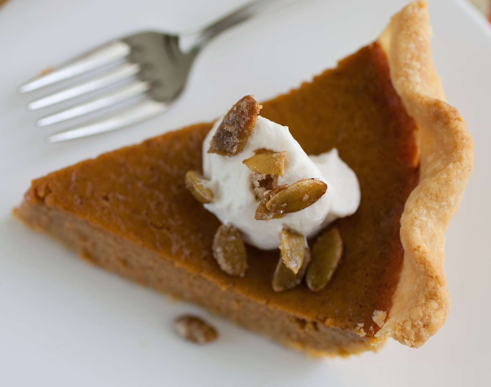 perfect pumpkin pie with maple whipped cream and sugared pumpkin seeds