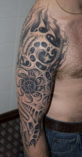 black & grey biomechanical tattoo covering the upper arm