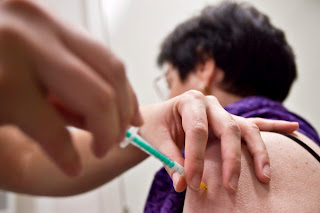 un enfermero inyecta una vacuna a una persona