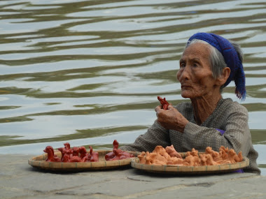 vieille femme vendant de l'artisanat sur son bateau