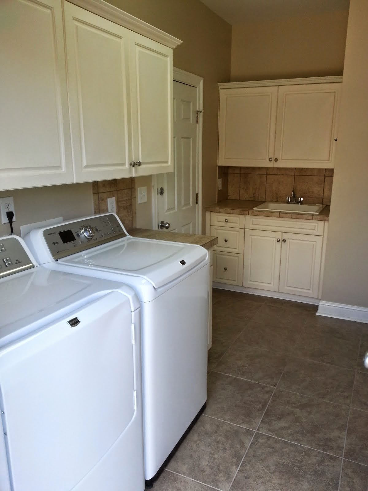 Laundry Room with Maytag XL washer/dryer & utility sink; door to 2-car Garage at left (new tile)