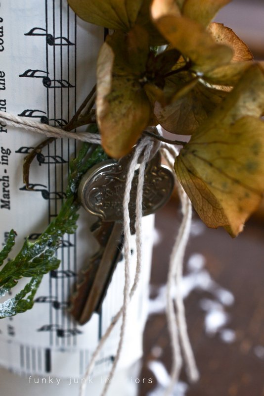 candle wrapped with greens, hydrangeas and key