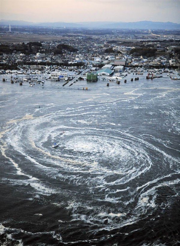 march 2011 tsunami japan. Tsunami swirls near a port in