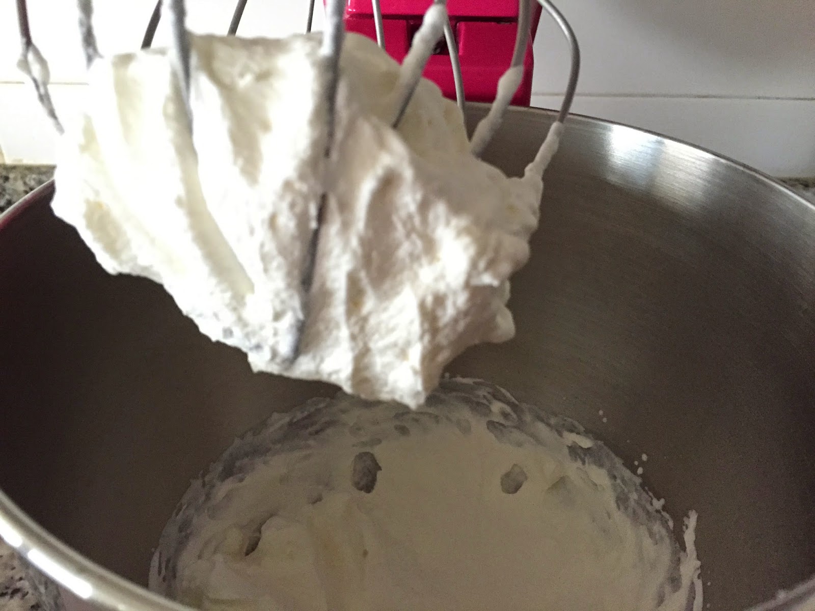 Cheesecake de nocilla blanca y frambuesas, batiendo la nata.