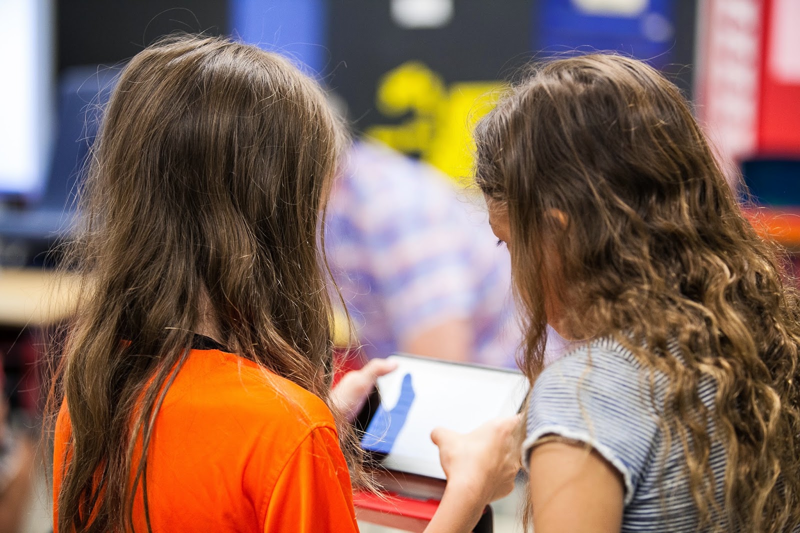 Two students looking at the screen of a tablet