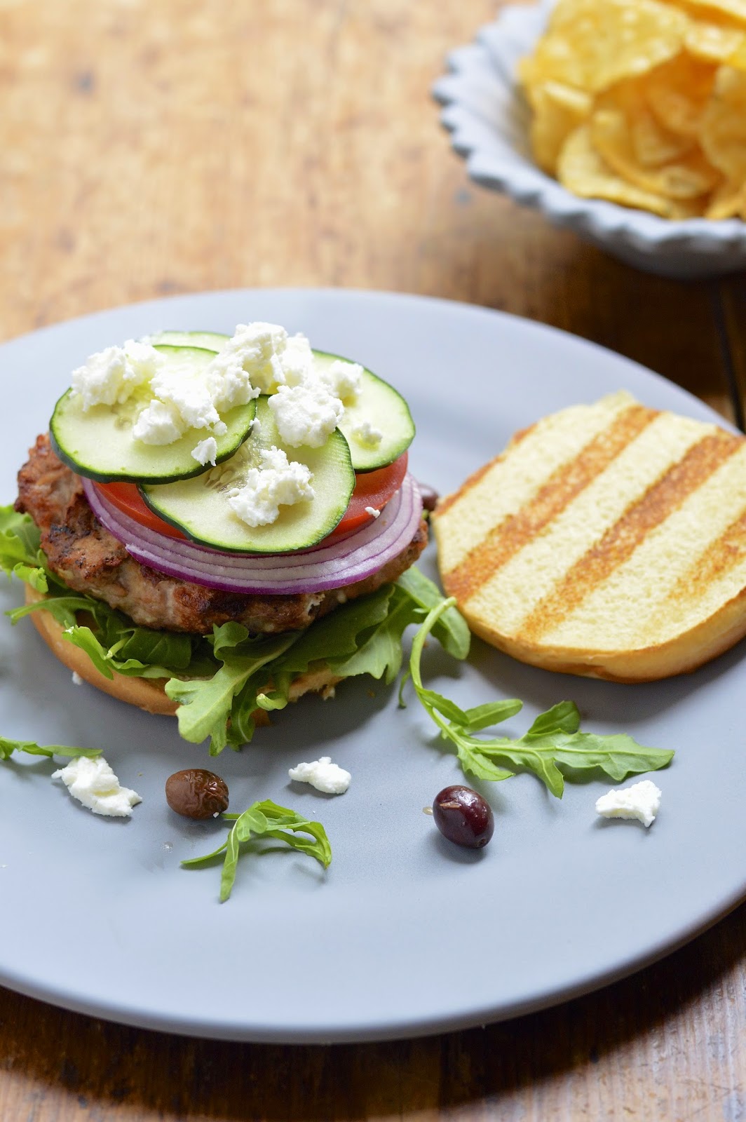 This grilled Greek turkey burger is packed with feta, olives and fresh vegetables and topped with a tangy vinaigrette. Perfect for your summer BBQ!