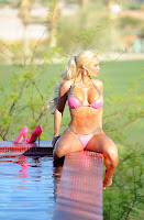 Coco Austin posing by the pool in a skimpy pink bikini
