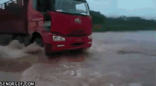 red truck sinks in flooded roadway lorry falls into swollen river after rain floods