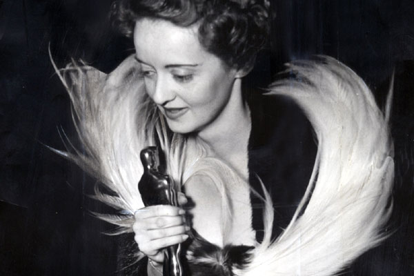 Bette Davis looking stunning in a feathered collar gown
