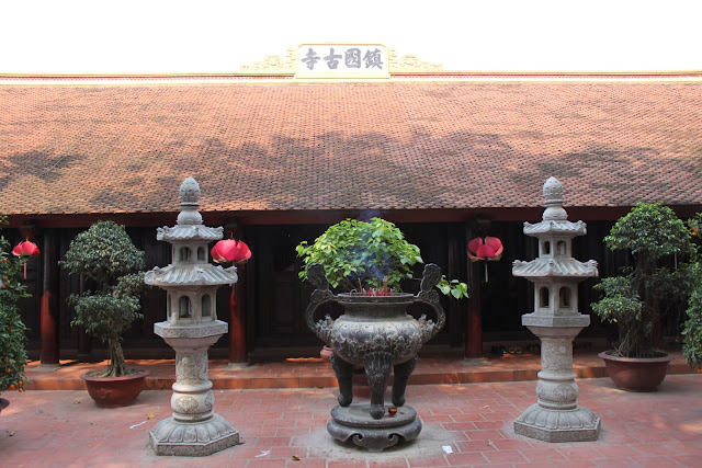 Buddhist temple with burning incense and worship statues is situated behind the oldest pagoda at Tran Quoc Pagoda in Hanoi, Vietnam Buddhist temple with burning incense and worship statues is situated behind the oldest pagoda at Tran Quoc Pagoda in Hanoi, Vietnam