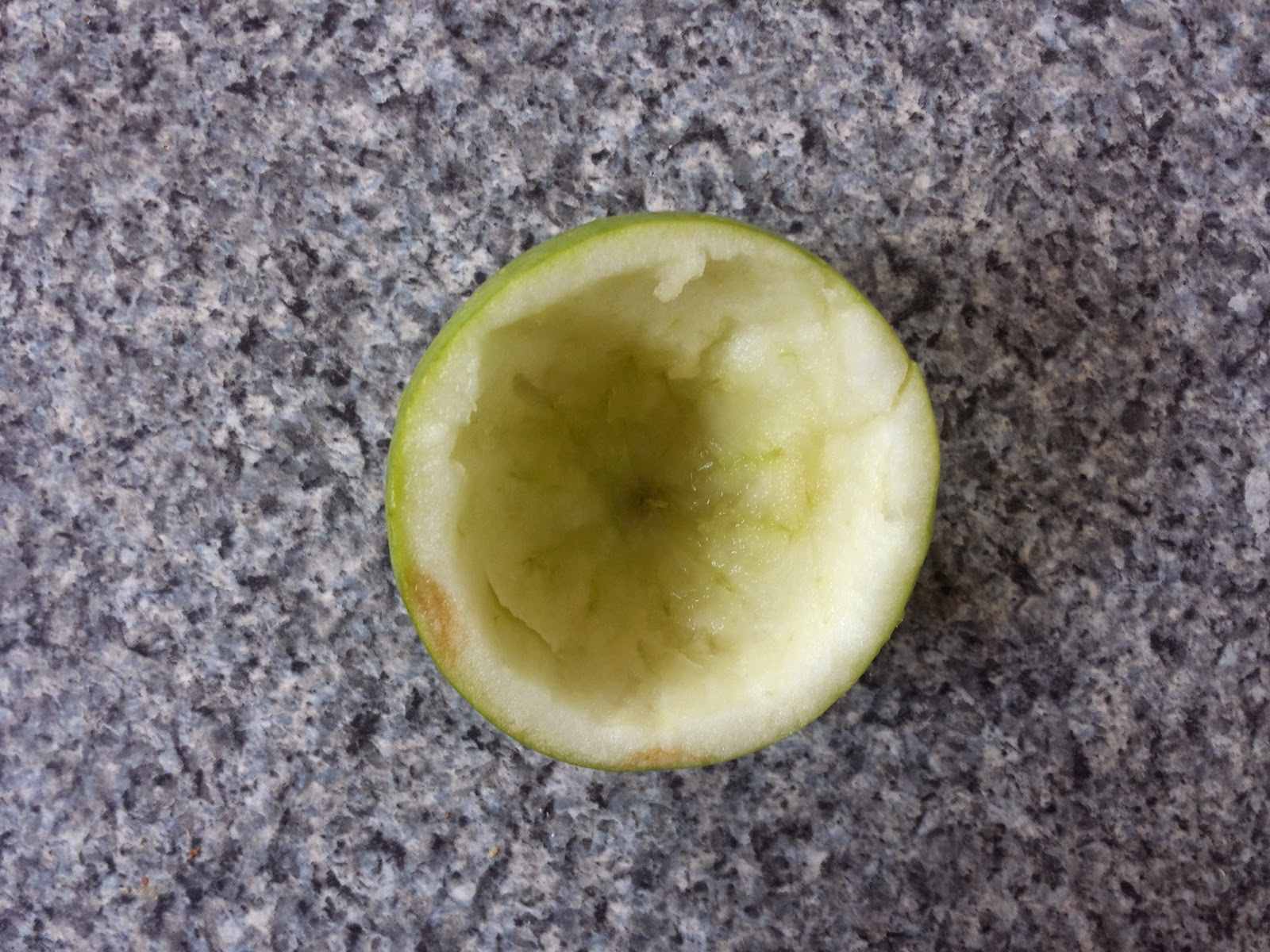 scooping out the flesh of the edible apple bowl