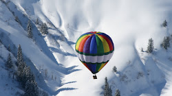 Globo aerostático sobrevolando los Pirineos nevados.