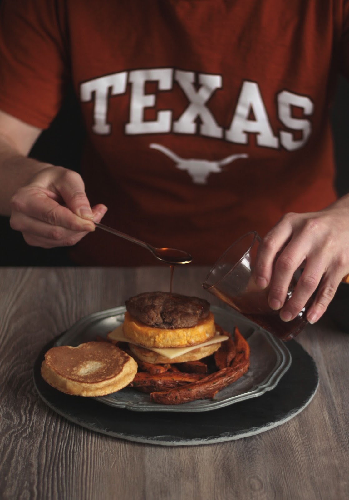 A Texas Pancake Sandwich with Egg and Ground Beef Pattie, Sweet Potato Fries and the best syrup of all times - Sriracha Flavored Maple Syrup - recipe brought to you by Pancake Stories.