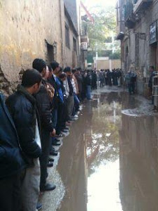 هذة ليست طوابير خبز ، بل للتصويت امام احدى اللجان با الاسكندرية ، بالرغم من هطول الامطار