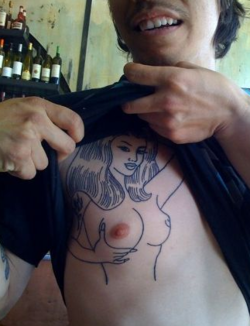 tatuaje de mujer en el costado del torso, simulando un pezon del tatuaje con el pezon real