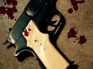 A gun on the murder scene with blood stains. A gun on the murder scene with blood stains.